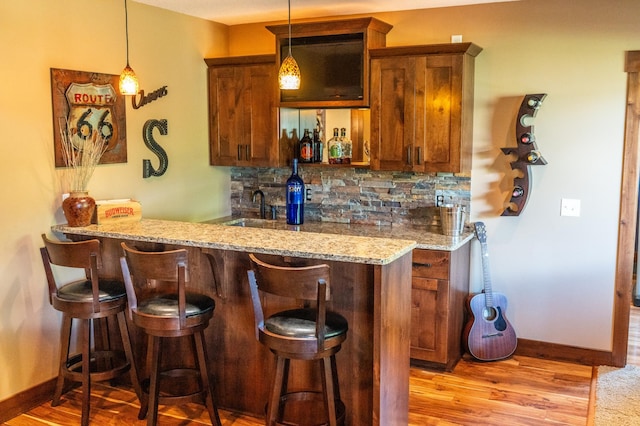 2441 Rosewood Ln SW, Rochester, MN 55902 - indoor wet bar featuring tasteful backsplash, baseboards, and decorative light fixtures