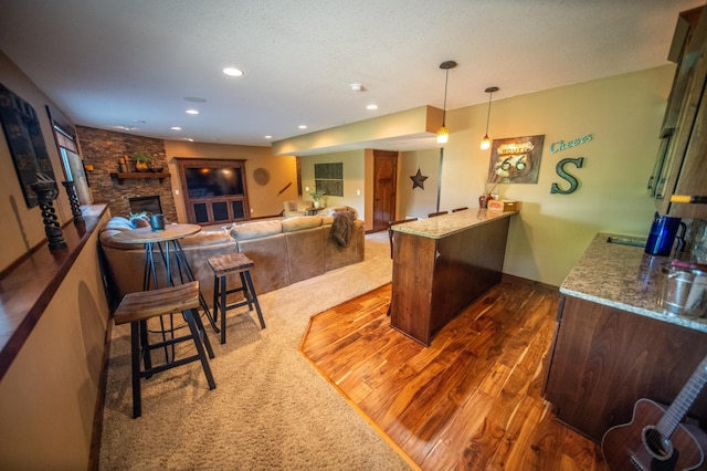 2441 Rosewood Ln SW, Rochester, MN 55902 - kitchen with a peninsula, wood finished floors, a fireplace, recessed lighting, and hanging light fixtures