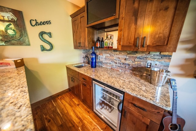 2441 Rosewood Ln SW, Rochester, MN 55902 - kitchen with wine cooler, decorative backsplash, light stone counters, and brown cabinetry