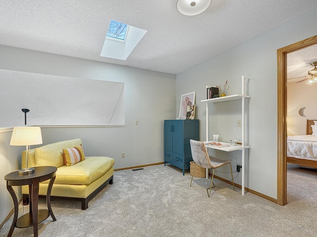 living area featuring a skylight, carpet flooring, a textured ceiling, and baseboards