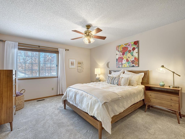 bedroom with baseboards, visible vents, ceiling fan, a textured ceiling, and carpet floors