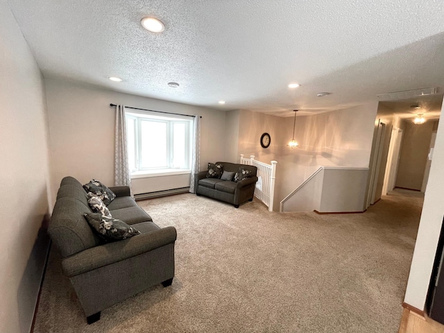 living room featuring a baseboard heating unit, carpet floors, and a textured ceiling