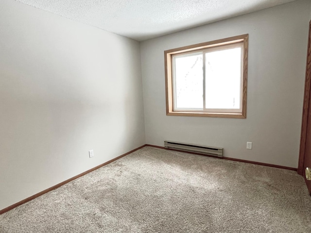 carpeted spare room featuring baseboard heating and a textured ceiling