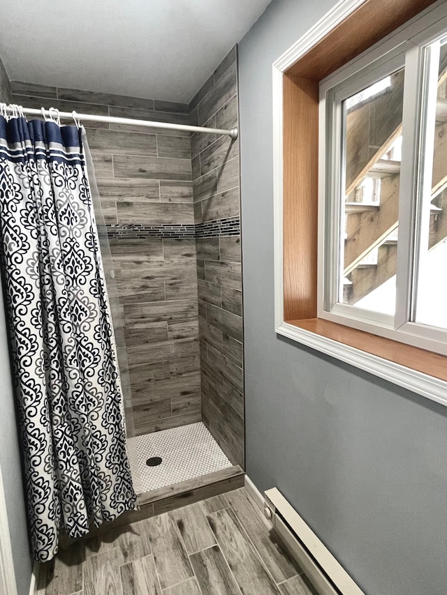 bathroom featuring baseboard heating and walk in shower