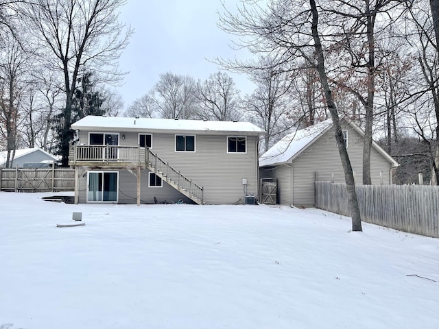 snow covered house featuring a wooden deck