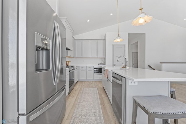 kitchen featuring white cabinetry, pendant lighting, stainless steel appliances, and a kitchen breakfast bar