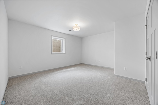 spare room featuring carpet floors and baseboards
