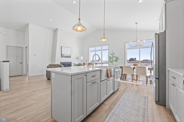 8334 61st St S, Horace, ND 58047 - kitchen featuring appliances with stainless steel finishes, a sink, a chandelier, light countertops, and an island with sink