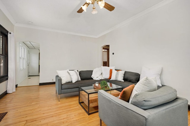 living room with hardwood / wood-style floors, crown molding, and ceiling fan