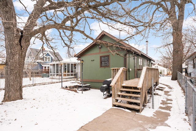 snow covered house featuring a wooden deck