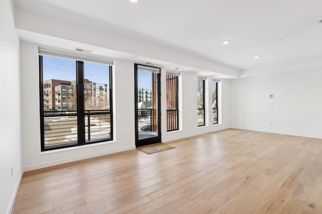 unfurnished room featuring a healthy amount of sunlight and light hardwood / wood-style floors