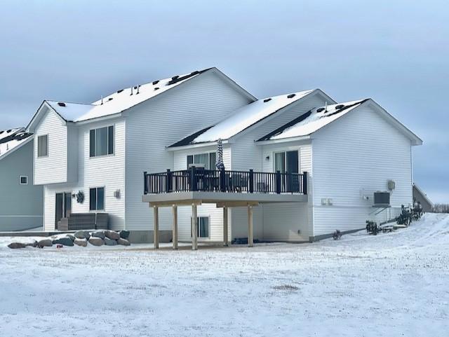 snow covered house with a wooden deck