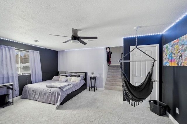 carpeted bedroom with ceiling fan, a textured ceiling, and baseboards