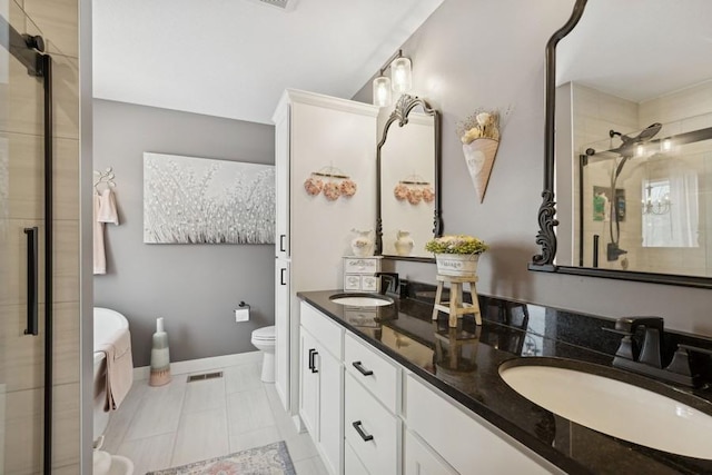 bathroom with a sink, a shower stall, toilet, and double vanity