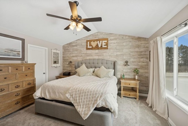 bedroom with lofted ceiling, light carpet, an accent wall, a ceiling fan, and baseboards