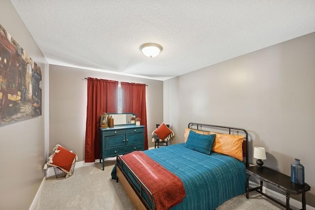 bedroom with light carpet, baseboards, and a textured ceiling