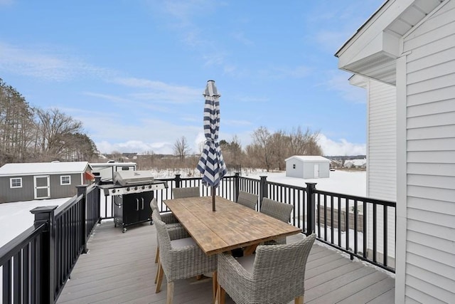 deck featuring an outbuilding, outdoor dining area, and a shed