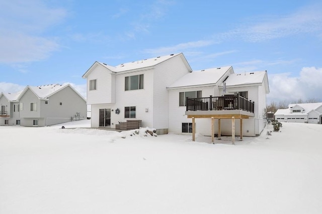 snow covered back of property featuring a deck