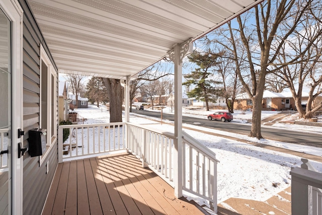 snow covered deck featuring a porch