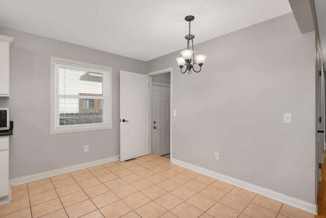 unfurnished dining area featuring light tile patterned floors and a chandelier