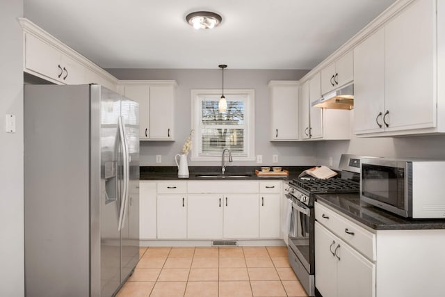 kitchen with sink, decorative light fixtures, light tile patterned floors, appliances with stainless steel finishes, and white cabinets