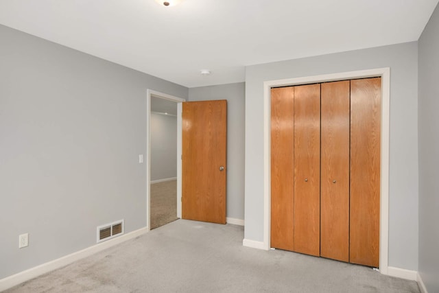 unfurnished bedroom with light carpet and a closet