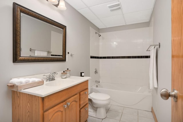 full bathroom with tiled shower / bath, a paneled ceiling, tile patterned flooring, vanity, and toilet