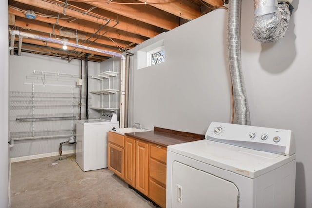 laundry area with separate washer and dryer, sink, and cabinets