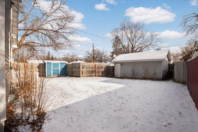 yard layered in snow with a shed