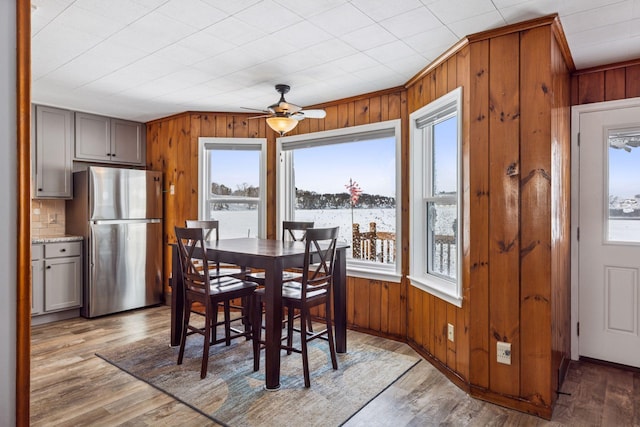 dining space featuring wooden walls and wood finished floors