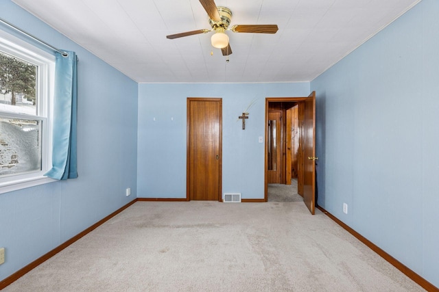 unfurnished bedroom featuring carpet floors, visible vents, baseboards, and a ceiling fan