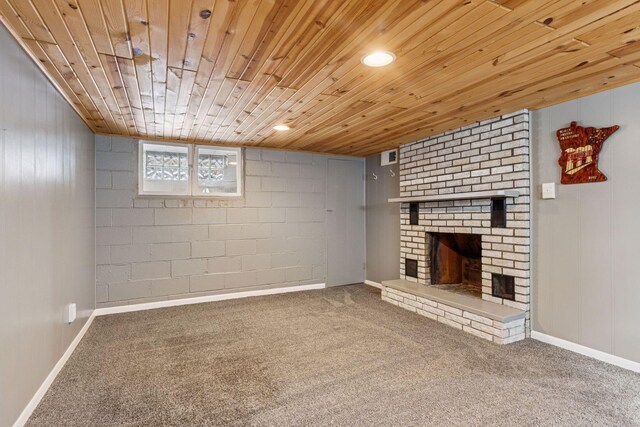 unfurnished living room with baseboards, visible vents, wood ceiling, carpet flooring, and a fireplace