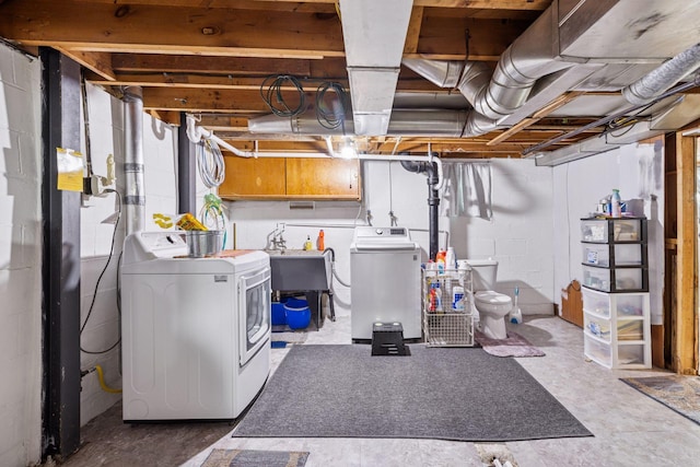 below grade area featuring a sink and washing machine and clothes dryer