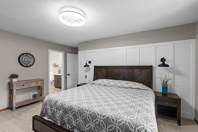 17130 Uplander Cir NW, Andover, MN 55304 - bedroom featuring light carpet, baseboards, connected bathroom, and a textured ceiling