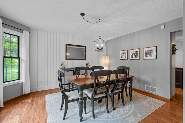 17130 Uplander Cir NW, Andover, MN 55304 - dining area featuring a textured ceiling, baseboards, light wood-style floors, and a chandelier
