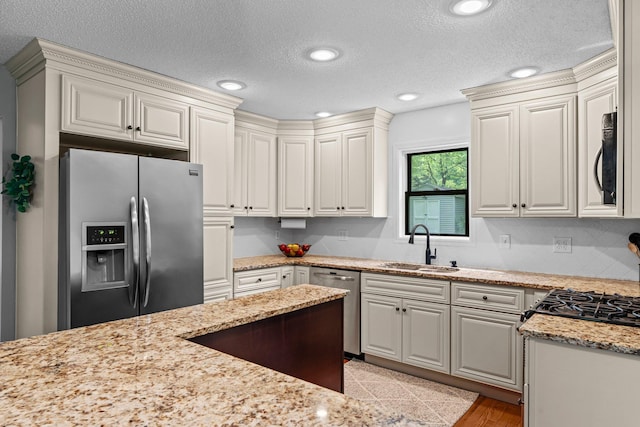 17130 Uplander Cir NW, Andover, MN 55304 - kitchen with stainless steel appliances, a sink, light stone counters, a textured ceiling, and recessed lighting