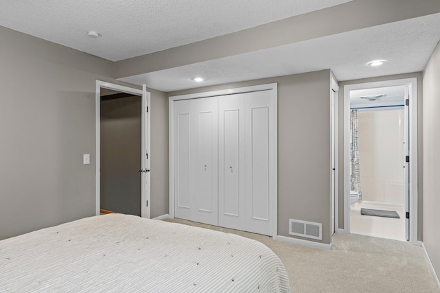 17130 Uplander Cir NW, Andover, MN 55304 - carpeted bedroom featuring a closet, baseboards, a textured ceiling, recessed lighting, and ensuite bathroom