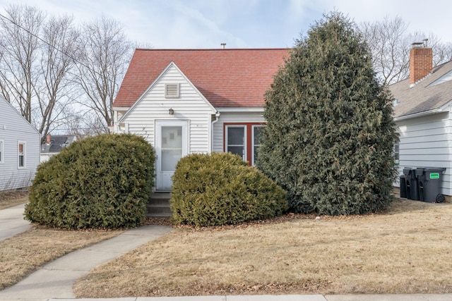 new england style home featuring a front yard