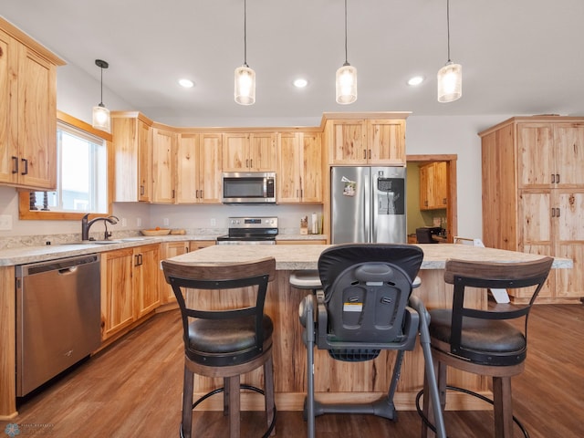 kitchen featuring light brown cabinets, a breakfast bar, and appliances with stainless steel finishes