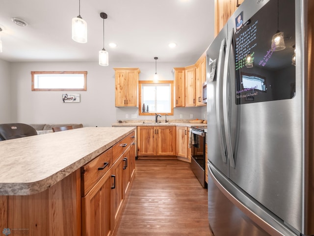 kitchen featuring hanging light fixtures, a wealth of natural light, a center island, and appliances with stainless steel finishes