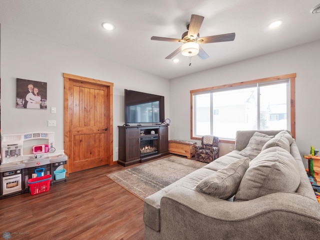 living room with wood-type flooring, a fireplace, and ceiling fan