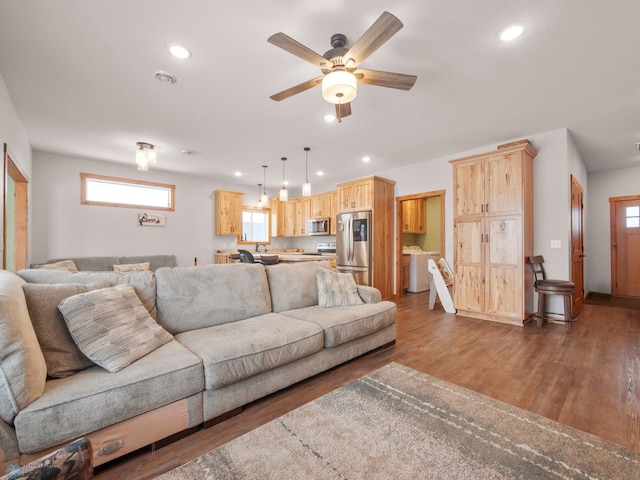 living room featuring plenty of natural light, dark wood-type flooring, and ceiling fan