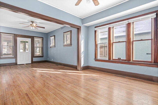 empty room with ornamental molding, ceiling fan, and light wood-type flooring