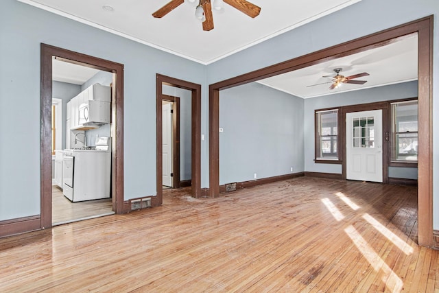 unfurnished living room featuring washer / dryer, crown molding, light hardwood / wood-style floors, and ceiling fan