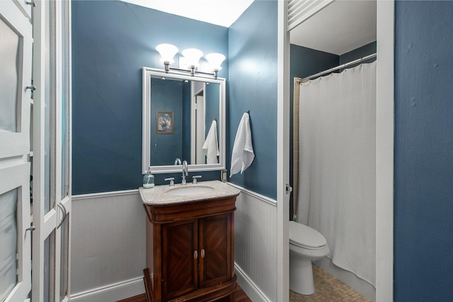 bathroom featuring vanity, toilet, and curtained shower