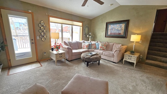 living area with baseboards, stairs, carpet floors, vaulted ceiling, and a ceiling fan