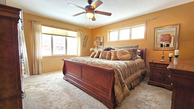 bedroom featuring a ceiling fan, light colored carpet, and a textured ceiling