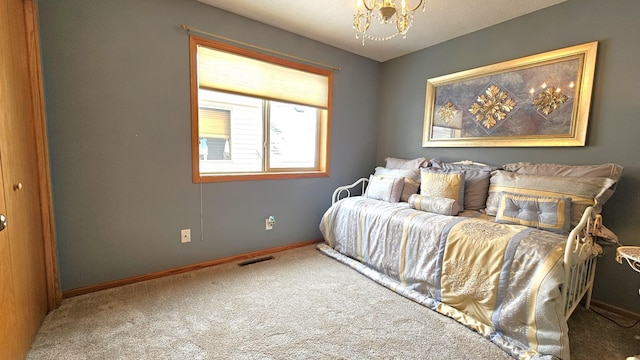 carpeted bedroom featuring a notable chandelier, baseboards, and visible vents