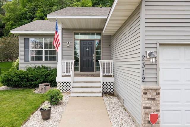 property entrance with a garage and a yard