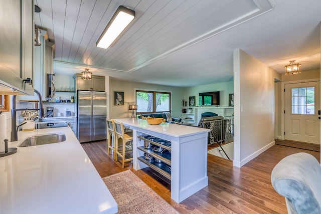 kitchen with appliances with stainless steel finishes, sink, a wealth of natural light, and dark hardwood / wood-style floors